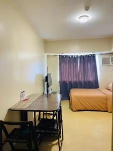 Cette chambre comprend un bureau, un lit et une table. dans l'établissement * * G Best value for the price!, à Iloilo