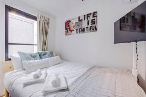 um quarto com uma cama branca e toalhas em アンドステイ池袋4丁目 em Tóquio