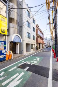 uma rua da cidade vazia com uma faixa verde e branca em アンドステイ池袋4丁目 em Tóquio
