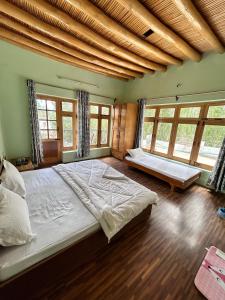 1 dormitorio grande con 1 cama grande y ventanas en Nilza Guest House, en Leh