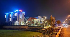 um edifício com luzes de néon numa rua à noite em Punita Hotel em Dien Ban