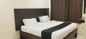 a bedroom with a large white and black bed at Arvind Stay Hotel, RK Beach Vizag in Visakhapatnam
