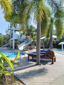 a resort swimming pool with a slide and palm trees at Marand Resort and Spa in Bauang
