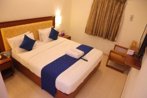 a bedroom with a large bed with blue and white sheets at A K Residency in Kālapettai