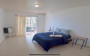 een slaapkamer met een bed met een blauwe sprei bij DIVERSITY HOTEL in Sosúa