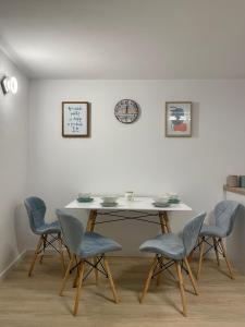 uma mesa com quatro cadeiras e um relógio na parede em RR HOUSE APARTAMENTS em Rasnov