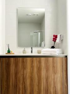a bathroom with a sink and a mirror at Urban Gem: Comfort, Style, Views. Apartment close to the AIRPORT in Guatemala