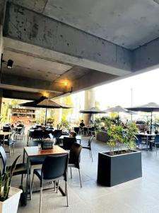 a restaurant with tables and chairs and umbrellas at Urban Gem: Comfort, Style, Views. Apartment close to the AIRPORT in Guatemala