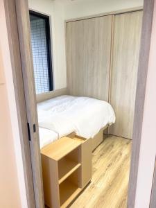 a small bed in a small room with a window at 暮嶼 twilight island in Toucheng