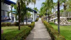 een loopbrug voor een gebouw met palmbomen bij DIVERSITY HOTEL in Sosúa