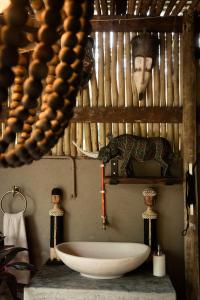un baño con bañera y una foto de un hombre en Grace of Africa, Couples 5 STAR Nature Lodge, en Marloth Park