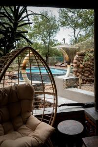 - un salon avec une chaise et une piscine dans l'établissement Grace of Africa, Couples 5 STAR Nature Lodge, à Marloth Park