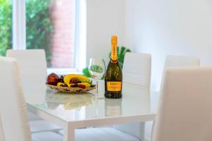 a bottle of wine and a bowl of fruit on a table at 3 Bed House - 8 Guests - Parking - Top Rated -162S - Netflix - Wifi - Smart TV in Birmingham