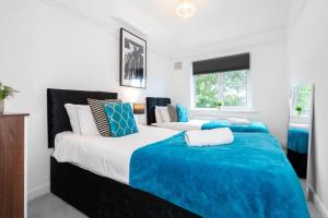 two beds in a bedroom with blue and white at 3 Bed House - 8 Guests - Parking - Top Rated -162S - Netflix - Wifi - Smart TV in Birmingham