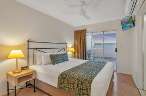 a bedroom with a large bed and a balcony at The Newport on Macrossan - Adults Only in Port Douglas