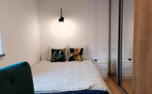 a bedroom with a bed with two pillows on it at theApartments Wojska Polskiego in Łódź