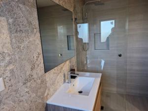 a bathroom with a white sink and a mirror at Cosy Secure comfortable for two in Canberra in Hall