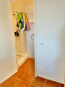 a bathroom with a shower with a door and a tile floor at Veuràs el Mar - Madrague Beach Studio 25 in Roses