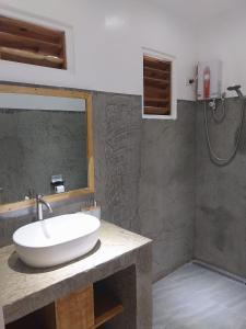 La salle de bains est pourvue d'un lavabo blanc et d'une douche. dans l'établissement Masayana, à El Nido