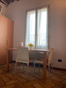 une table à manger avec deux chaises et une fenêtre dans l'établissement Appartamento Saragozza, à Bologne