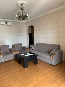 a living room with two couches and a coffee table at Apartment On Botanikuri 17 in Tbilisi City