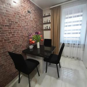 uma sala de jantar com uma parede de tijolos e uma mesa e cadeiras em Lux apartment in city center em Kremenchuk