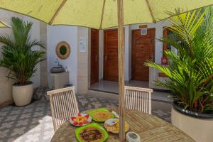 a table with a plate of food and an umbrella at Seven Angels Villa and Hostel in Nusa Penida