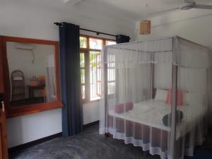 a bedroom with a canopy bed and a mirror at Bella Nilaveli Beach in Nilaveli +82 photos