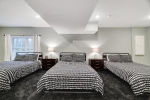 a bedroom with two beds with black and white sheets at Lagniappe Lodge Spa, Views, Life Memories in Tafton