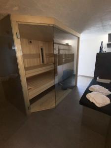 Pokój z przeszkloną ścianką z łóżkiem i ręcznikami w obiekcie Kuća za odmor KODBA w mieście Štrigova