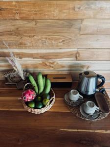 a table with a bowl of vegetables and a tea kettle at Uma Pantai Seseh in Canggu