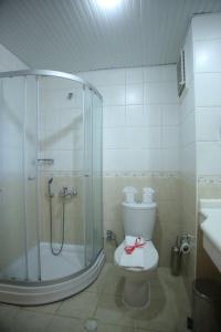 a bathroom with a shower and a toilet with a bow on it at Sayanora Hotels Side in Side