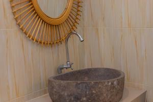 a stone sink in a bathroom with a mirror at Seven Angels Villa and Hostel in Nusa Penida