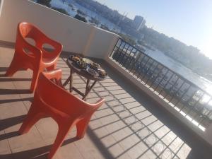 2 krzesła i stół na balkonie z widokiem na wodę w obiekcie FADL Kato w mieście Aswan
