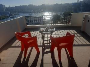 two red chairs and a table on a balcony at FADL Kato in Aswan