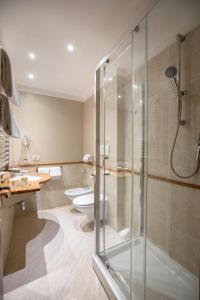 a bathroom with a glass shower and a toilet at Charme Hotel in Prato