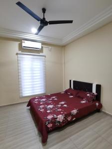 a bedroom with a bed and a ceiling fan at Villa Tok Wan in Kuantan