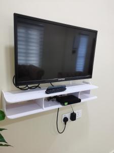 a flat screen tv on a white shelf at Villa Tok Wan in Kuantan