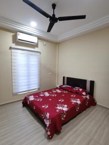 um quarto com uma cama com um cobertor vermelho em Villa Tok Wan em Kuantan