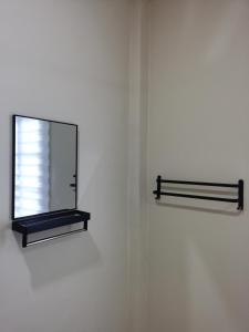 un espejo en una pared con un estante en Villa Tok Wan, en Kuantan
