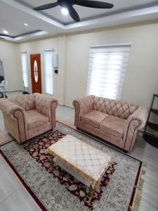 a living room with two couches and a coffee table at Villa Tok Wan in Kuantan