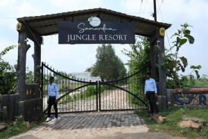 two men standing in front of a gate at Samardha Jungle Resort in Bhopal