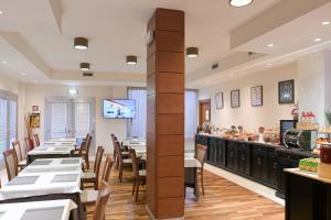 una sala da pranzo con tavoli e bancone in un ristorante di Charme Hotel a Prato