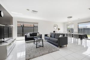 a living room with two couches and a table at Modern 4BR house perfect for family getaway in Point Cook