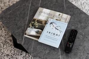 a book and a remote control sitting on a table at Modern 4BR house perfect for family getaway in Point Cook