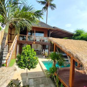 une maison avec une terrasse et une piscine dans l'établissement Villa Bagheera, à Gili Trawangan