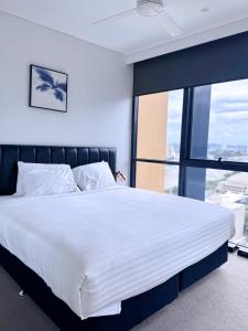 a large bed in a room with a large window at Urban Riverside Escape at Cultural Centre Precinct in Brisbane
