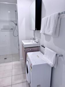 a bathroom with a washing machine and a sink at Urban Riverside Escape at Cultural Centre Precinct in Brisbane