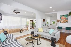 a living room with a couch and a table at The Queenslander! Complete Entertainer - Huge - Stylish - Games - Full Level Pool Room - Smokehouse - Secure Parking - Yard #NEW! in Gold Coast