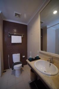 a bathroom with a sink and a toilet and a mirror at Noola Inn Hotel Bogor in Kamparganya +31 photos